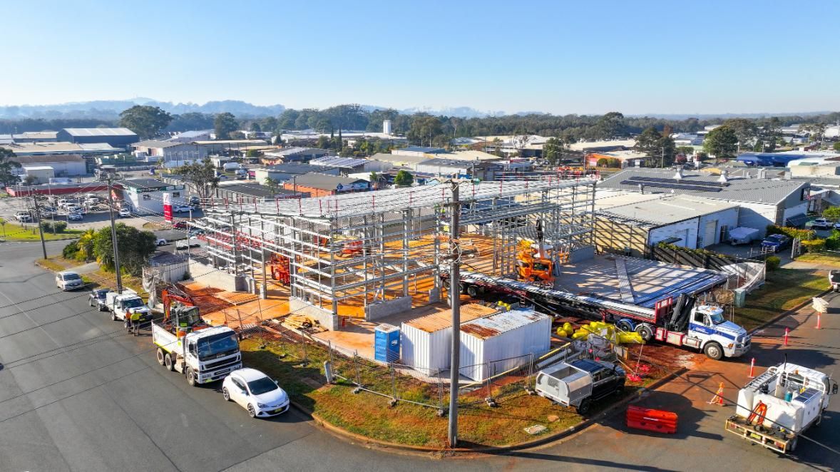 View of a Construction Site with Trucks Parked on the Side of the Road — Roofing Contractor in Forster, NSW