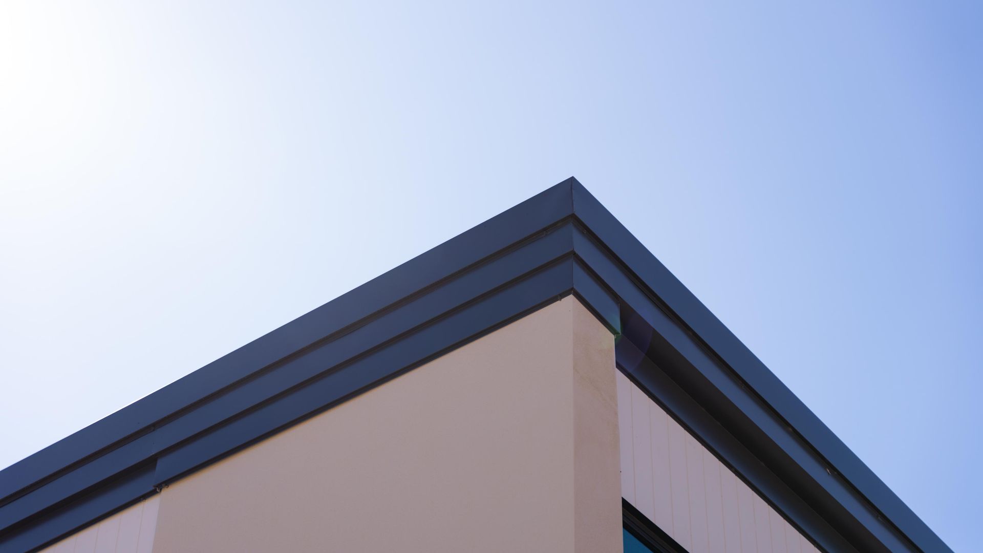 Looking Up at the Corner of a Building with a Blue Sky in the Background — Roofing Contractor in Wauchope, NSW