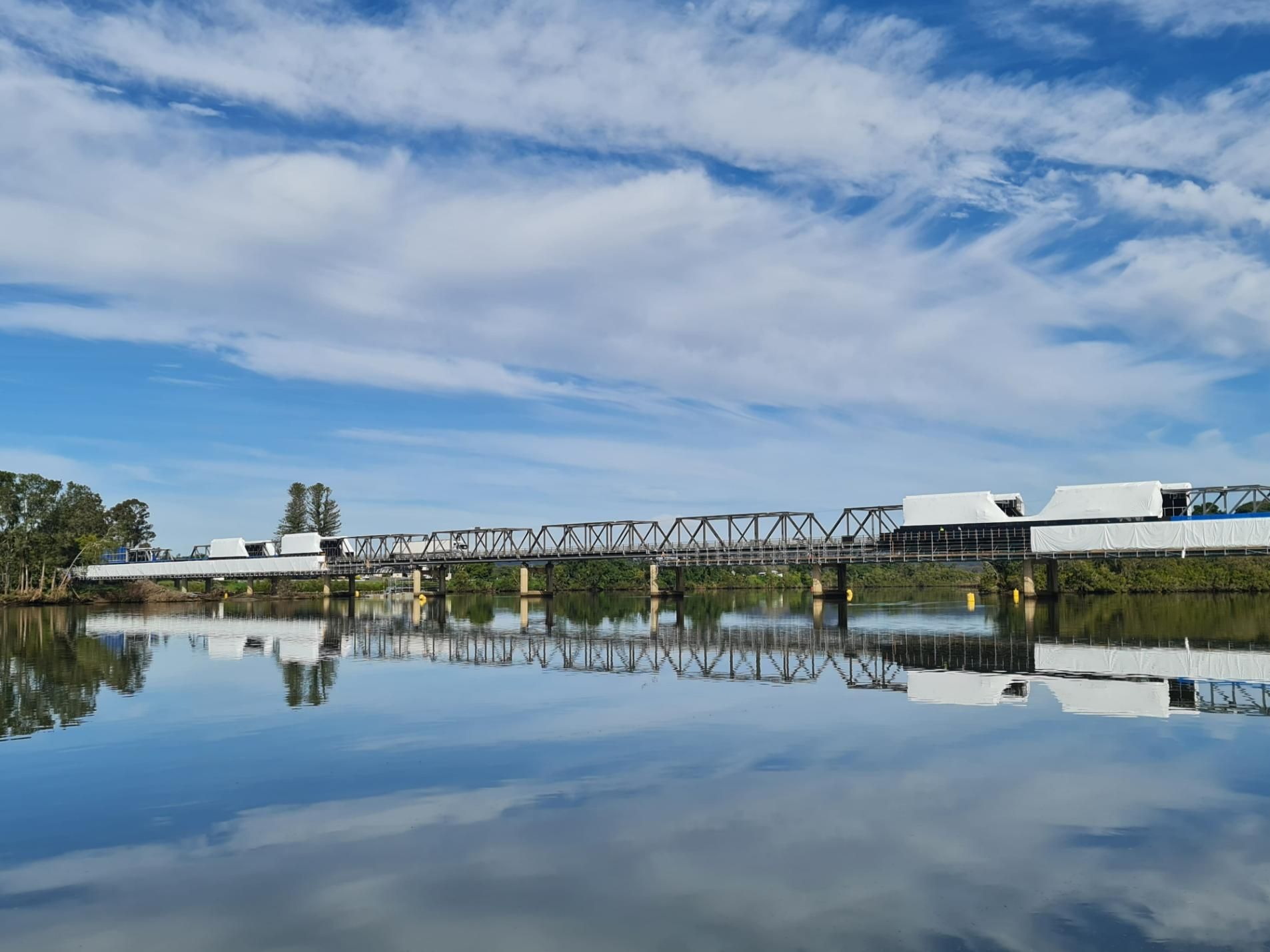 A Bridge Over A Body Of Water With A Blue Sky in the Background — Roofing Contractor in Taree, NSW