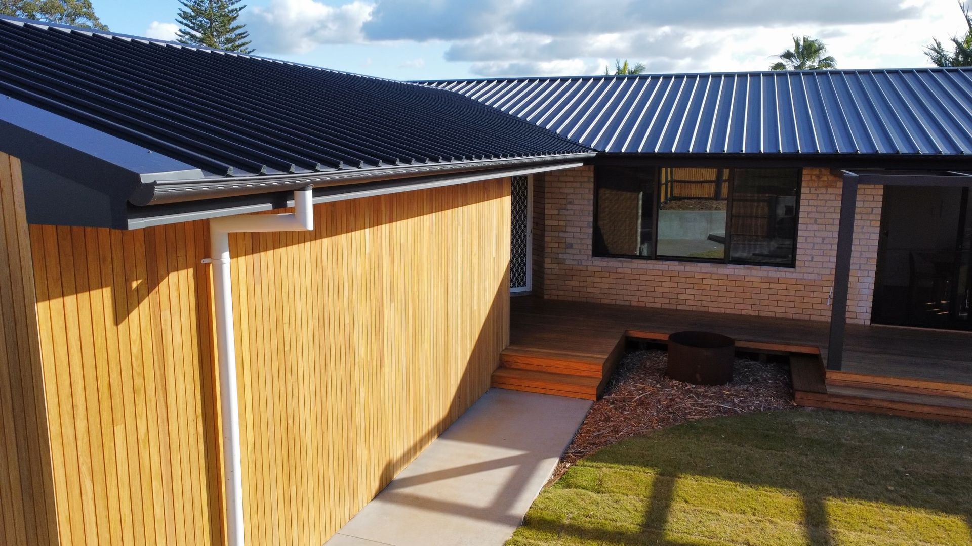 A Man is Working on a Stack of Metal Sheets at a Construction Site — Roofing Contractor in Wauchope, NSW