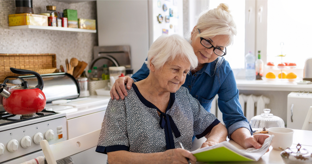 Daughter helping elderly mom with bills 