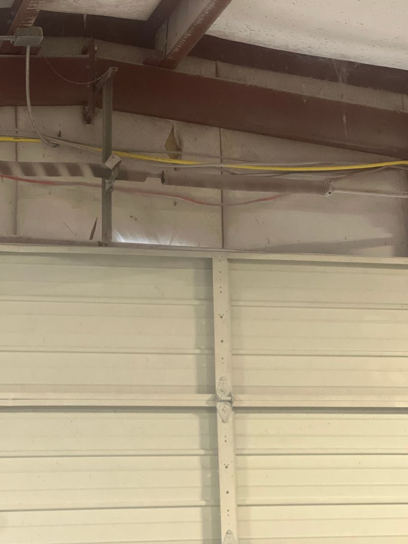 Garage door technician performing maintenance inspection