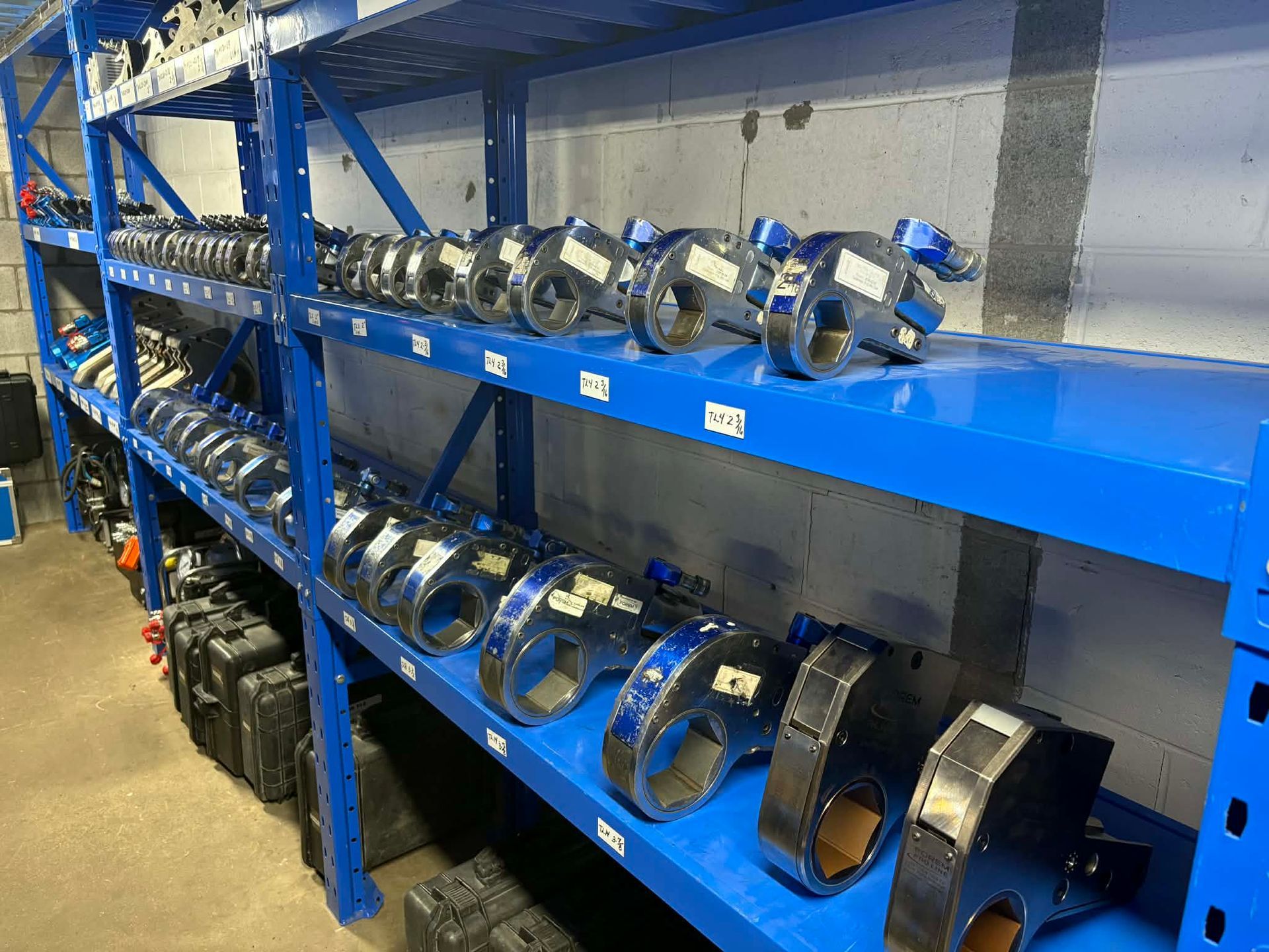 Étagère bleue remplie de pièces métalliques industrielles.