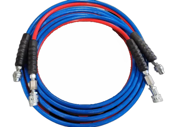Tuyaux bleus et rouges enroulés avec poignées noires et raccords métalliques.