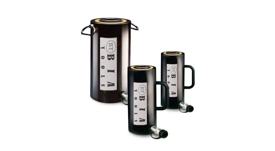 Trois vérins hydrauliques noirs avec poignées et raccords, sur fond blanc.