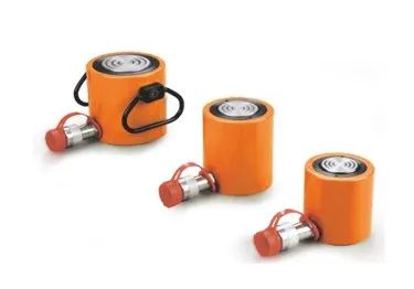 Trois vérins hydrauliques orange avec raccords argentés et bouchons rouges sur fond blanc.
