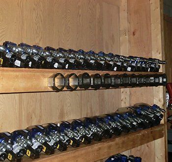 Des étagères contenant de nombreux outils bleus et argentés, à l'intérieur d'une pièce lambrissée.