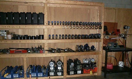 Wooden shelves filled with tools and equipment in a workshop.
