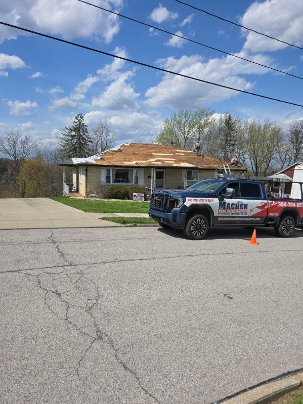 Branded truck parked on a suburban street in front of a house, with an orange cone nearby.
