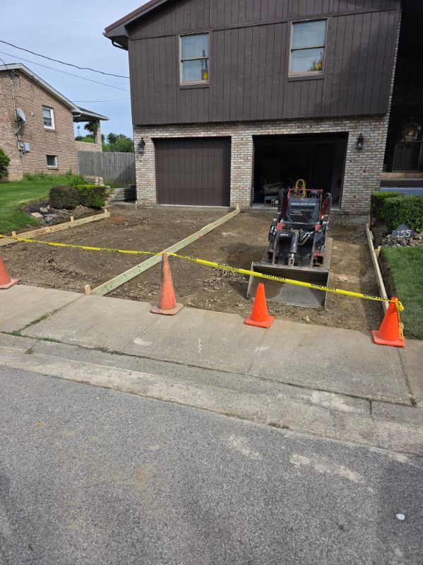 Driveway with two small cones in front of a garage and house facade