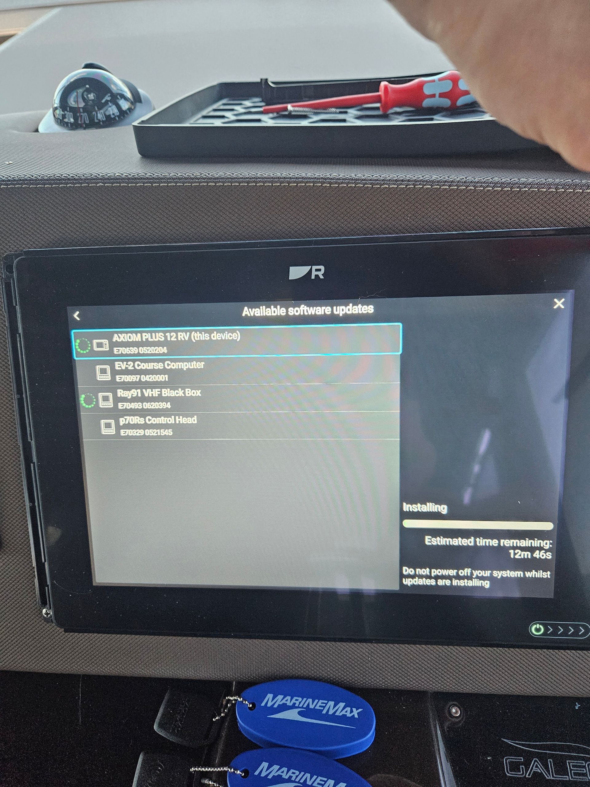 A digital dashboard screen displays a software update in progress with a progress bar and a list of updated components.