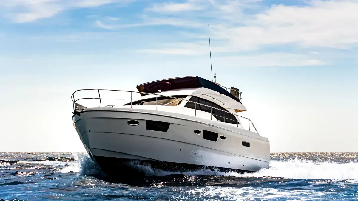 White yacht cruising on choppy blue water under a clear sky