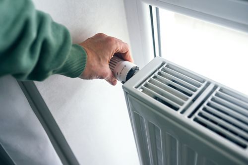 A Person Is Adjusting A Thermostat On A Radiator - Maricopa, AZ - Eco Mechanical LLC