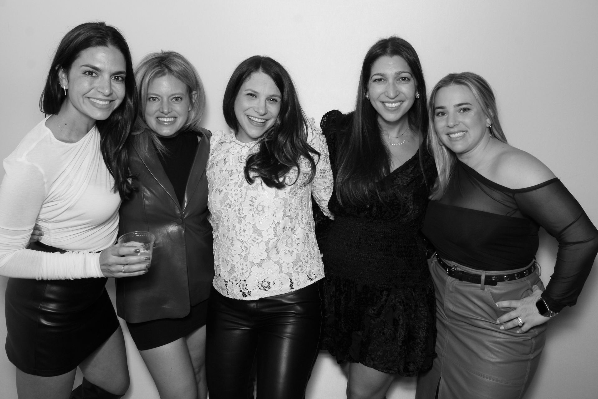 Friends pose together for a black-and-white photo booth picture during the event.