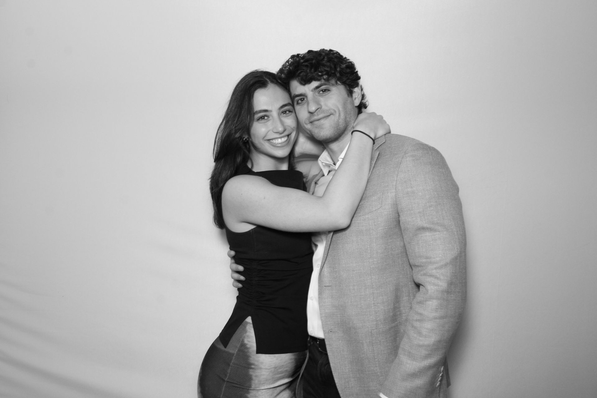 Studio-style black and white glam booth portrait capturing a couple during a formal celebration.