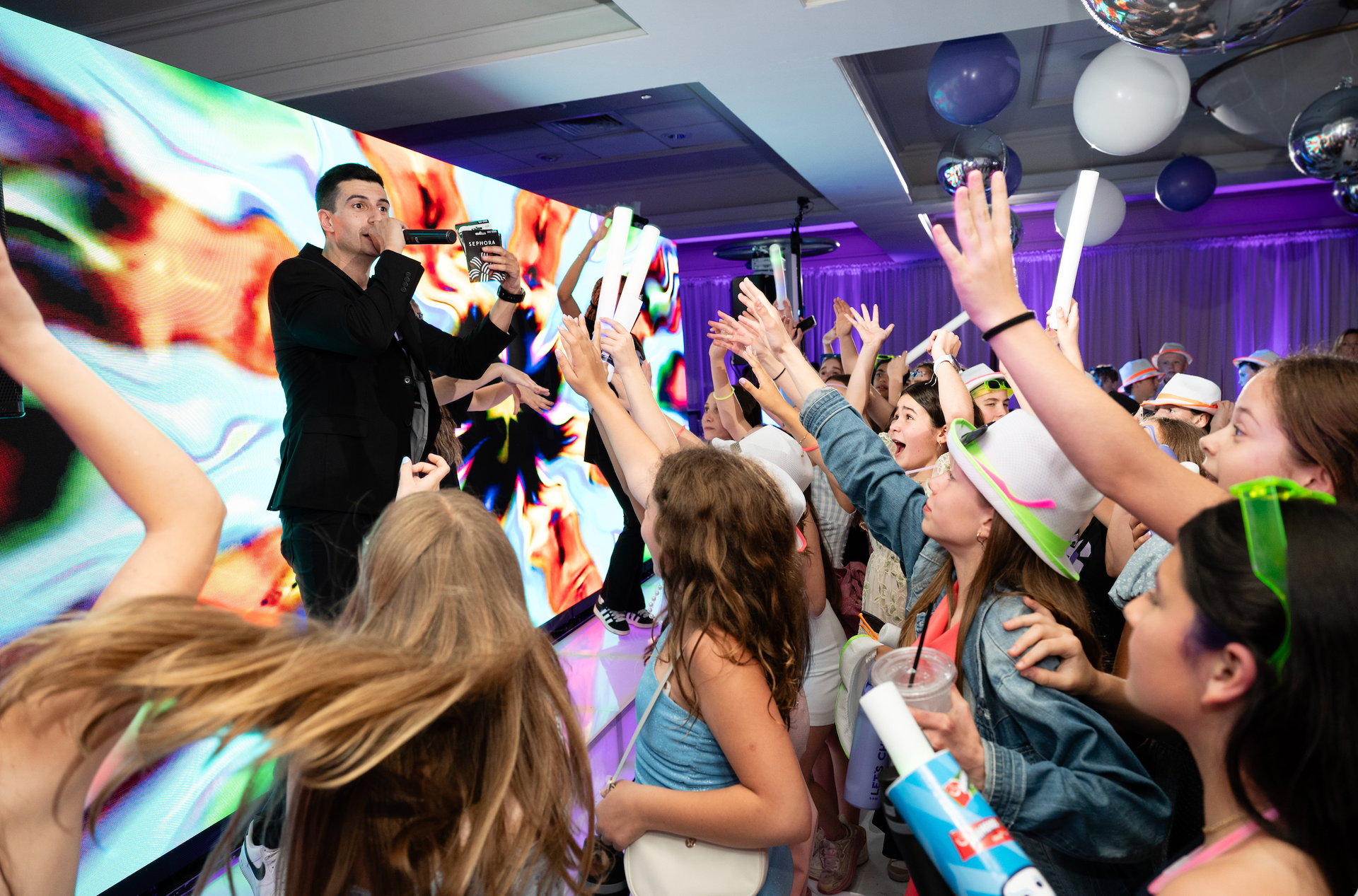 MC Ethan Mazer performing live in front of a large crowd of 175 people.