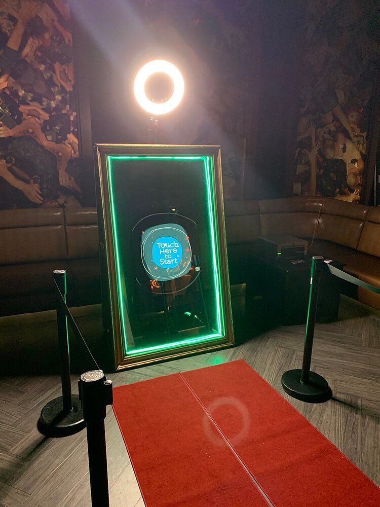 The Magic Mirror photo booth stands out with its interactive touch screen and elegant frame.