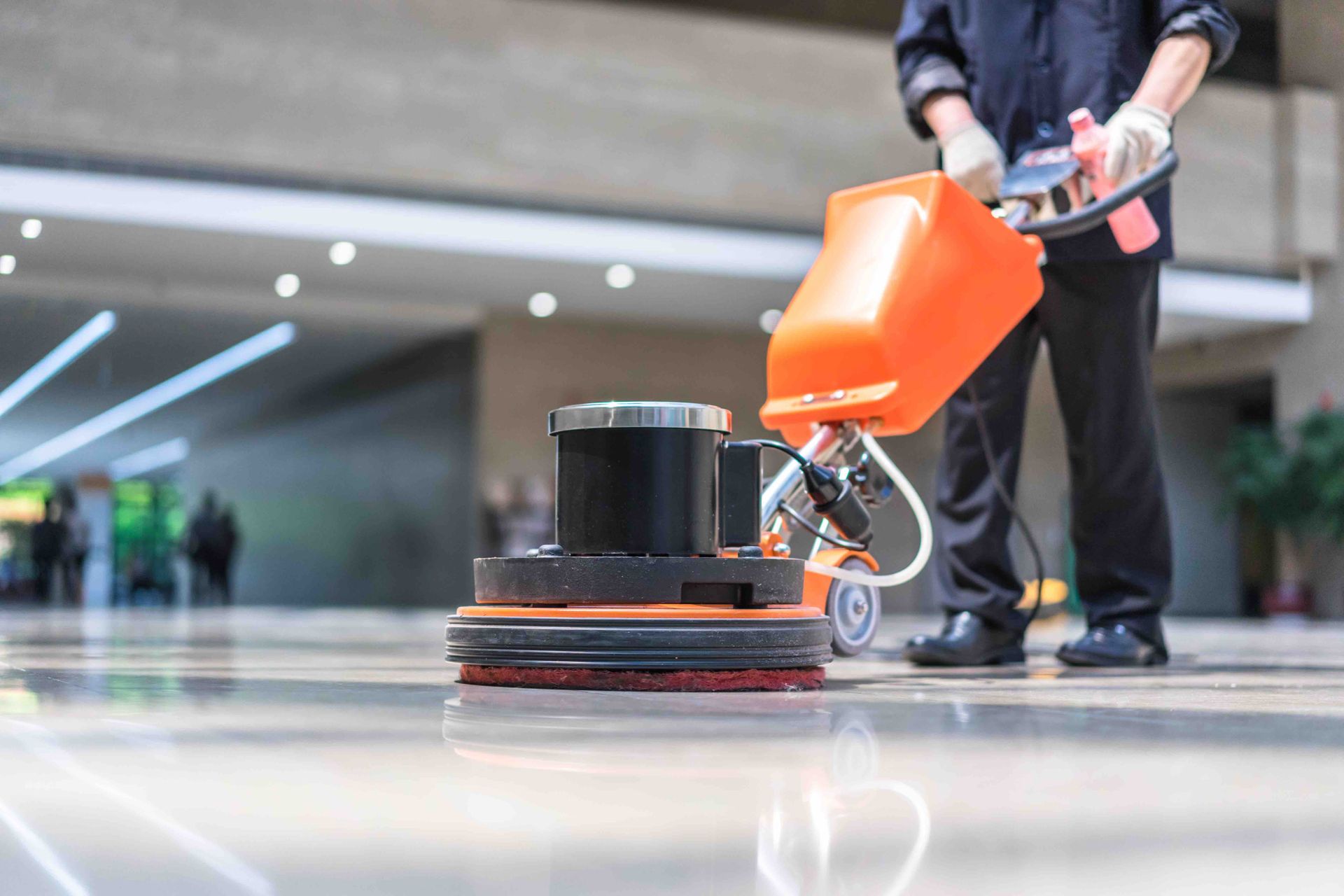 A man is cleaning the floor with a machine.