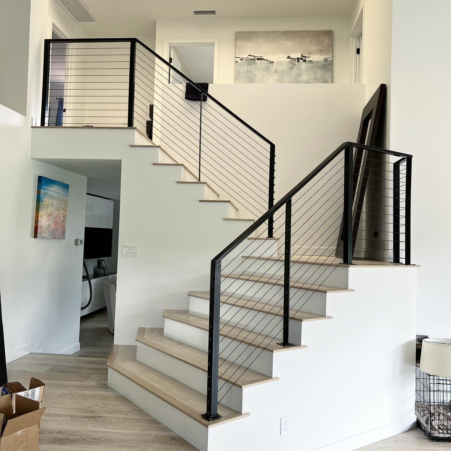 A white staircase with a black railing in a living room
