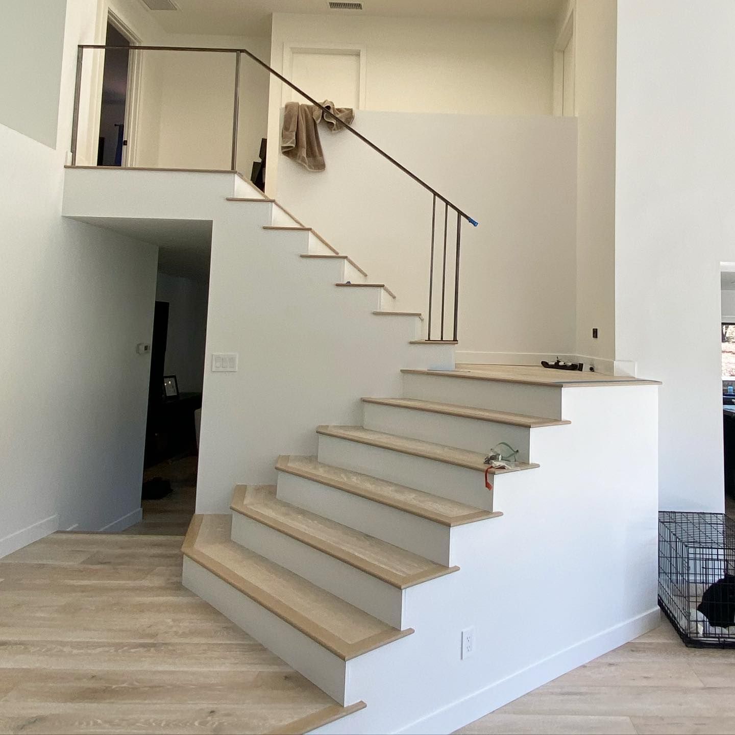 A white staircase with wooden steps and a metal railing