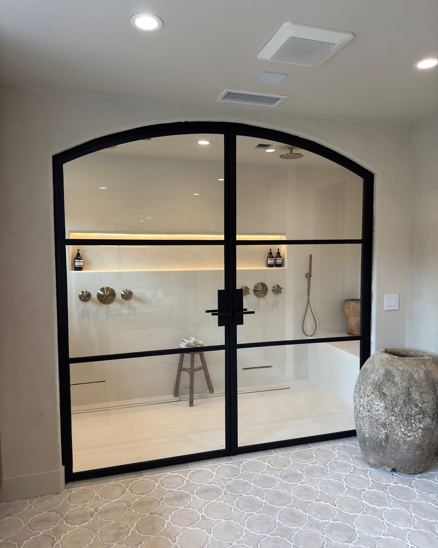 Arched black steel and glass door in a bathroom