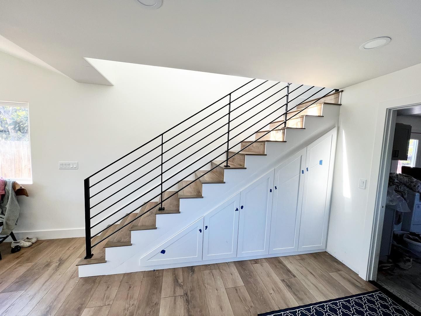 Horizontal bar stair railing over built-in cabinets