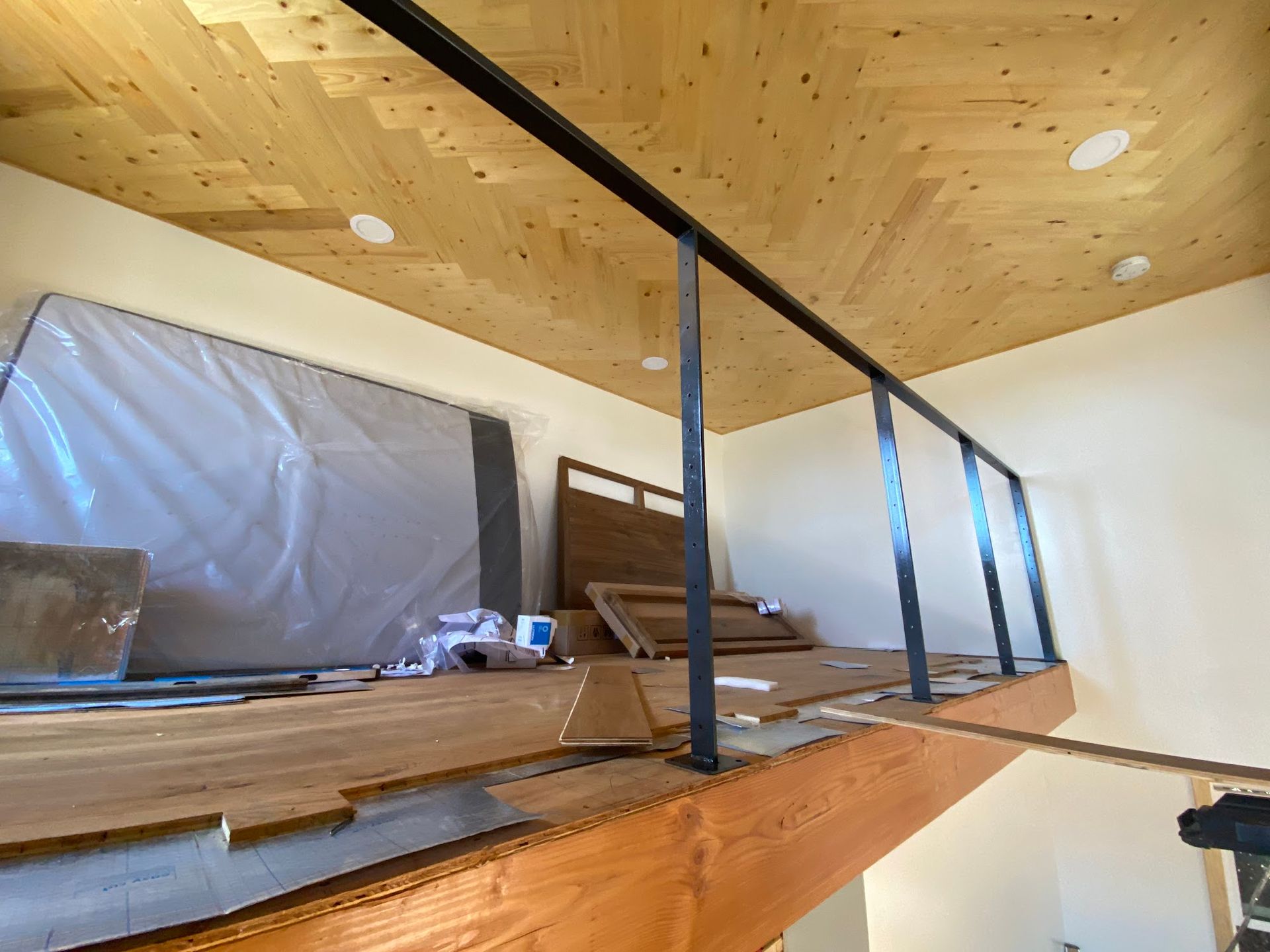 A room with a wooden ceiling and a metal railing.
