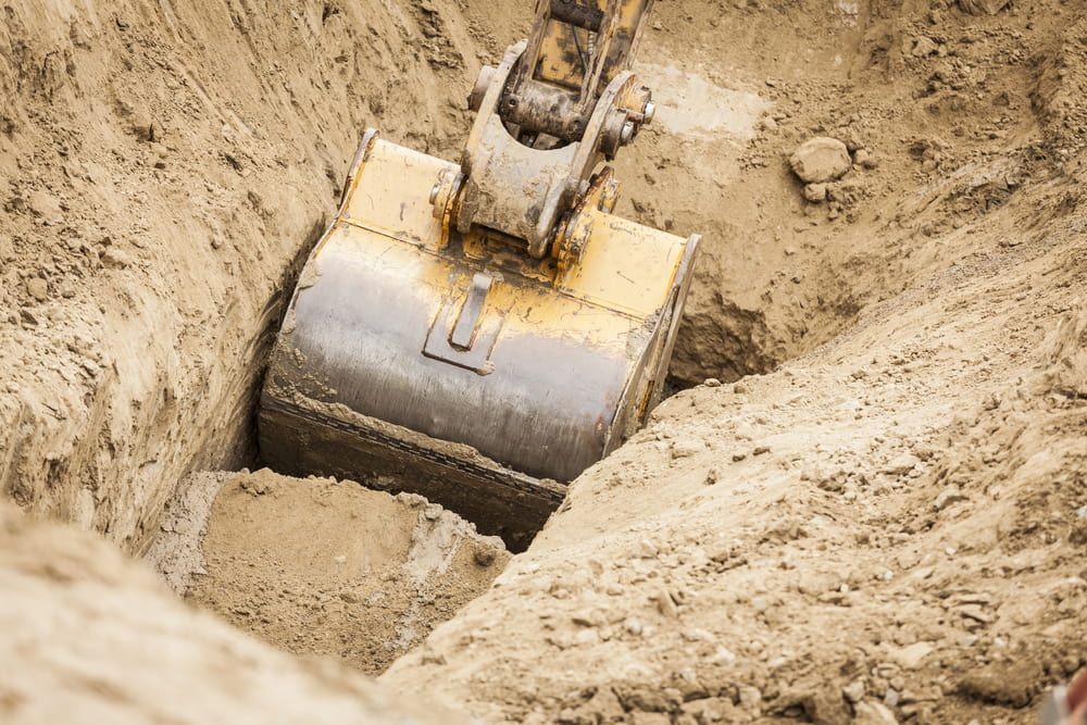 A Bulldozer is Digging a Hole in the Ground — North Coast Drilling & Wicks in Bangalow, NSW