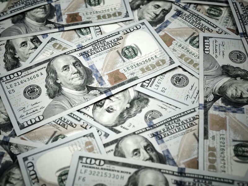 Scattered US hundred-dollar bills in a close-up view