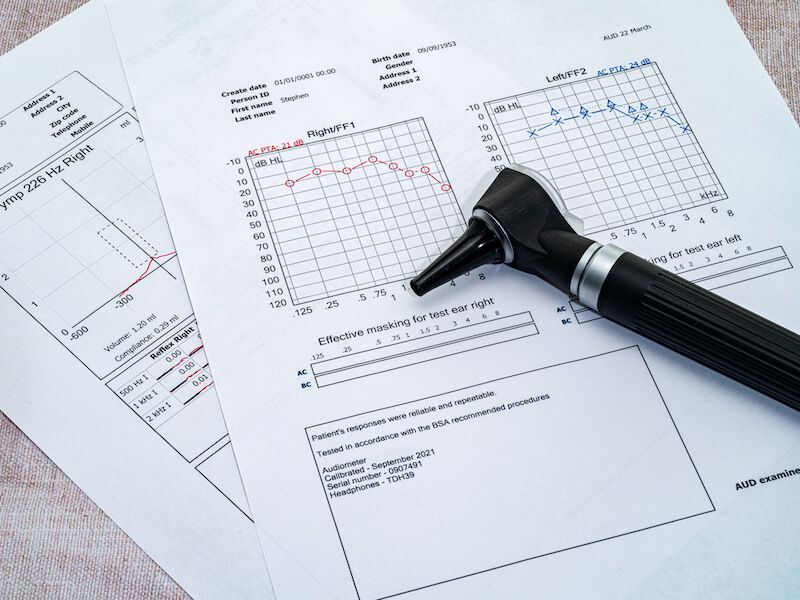 Stethoscope on medical charts with line graphs and a blank report form