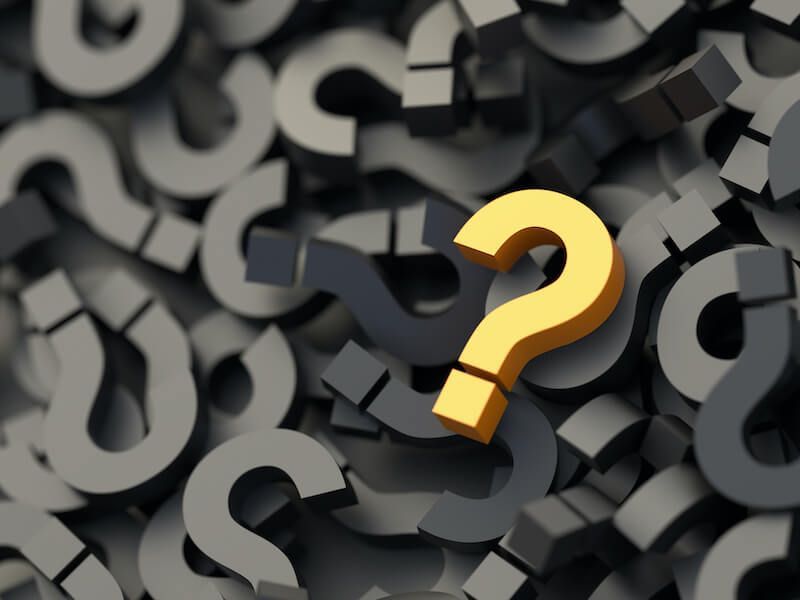 Gold question mark on a pile of dark gray question marks