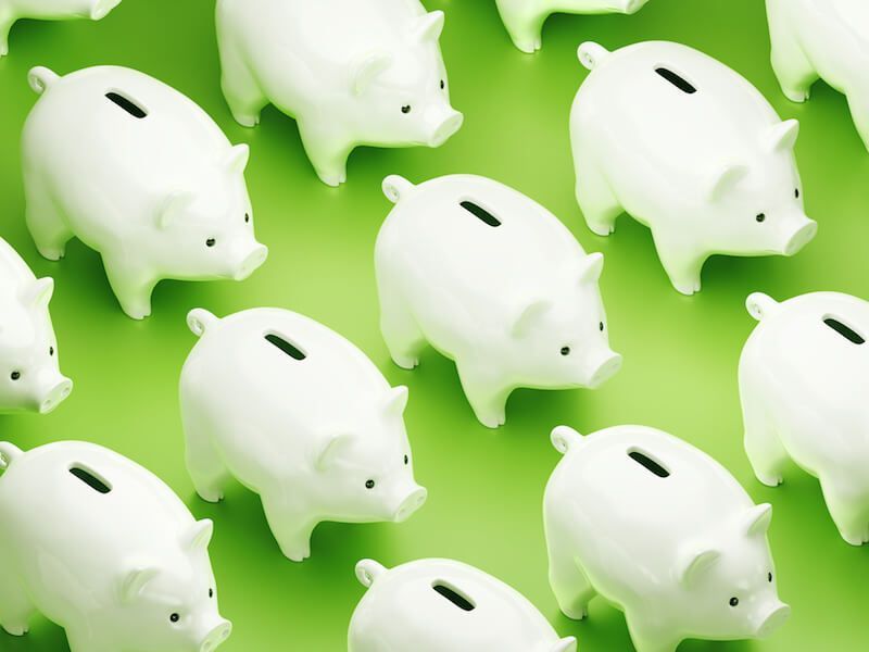 White piggy banks scattered on a bright green background.