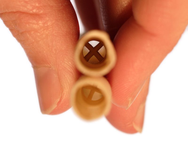 Two hands holding two beige cable ends with X-shaped openings close together