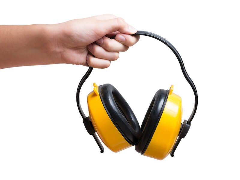 Hand holding yellow and black earmuffs by the headband