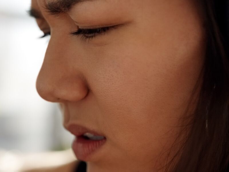 Close-up side profile of a person with eyes closed, appearing calm or contemplative.