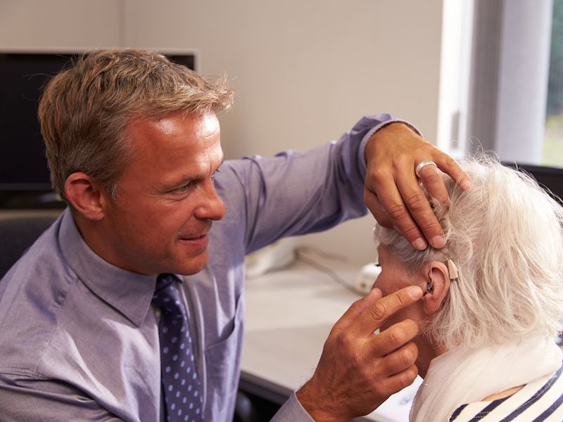 Doctor examining an elderly patient’s ear in a clinic