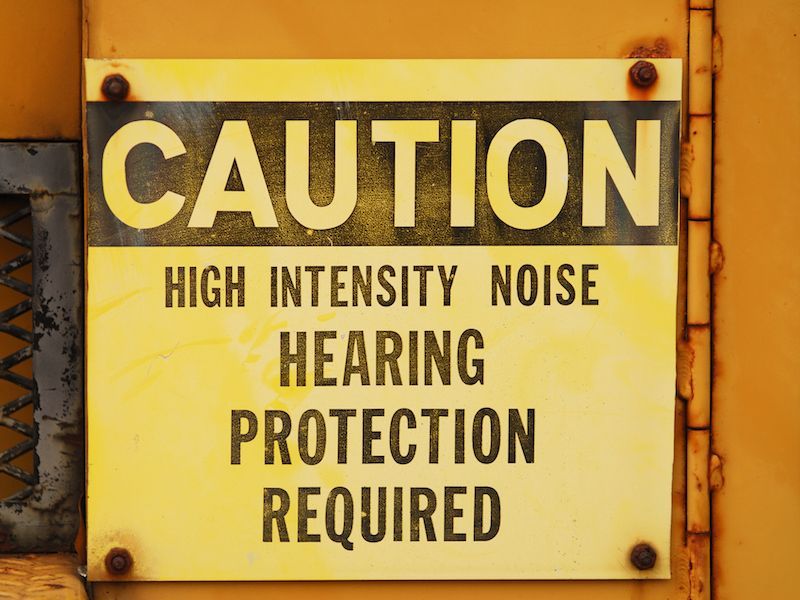 Yellow caution sign reading “High Intensity Noise Hearing Protection Required”