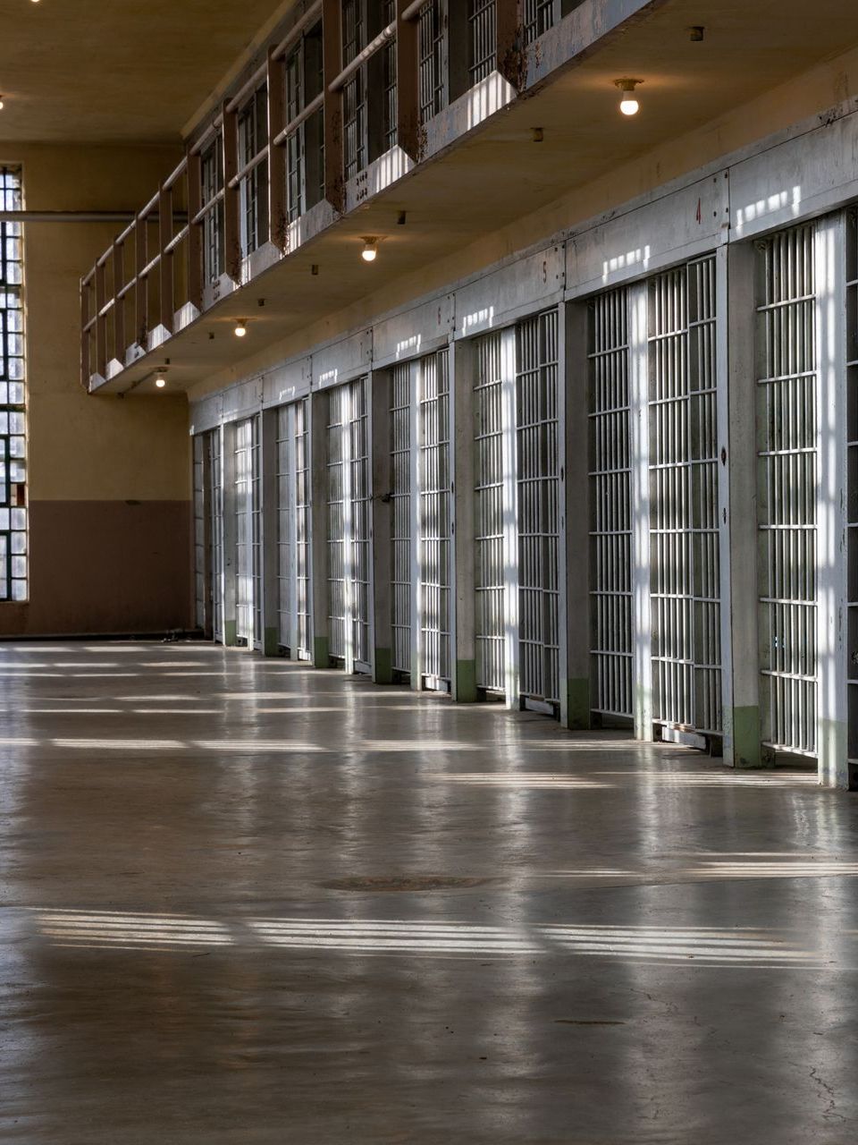 A row of prison cells with a lot of windows