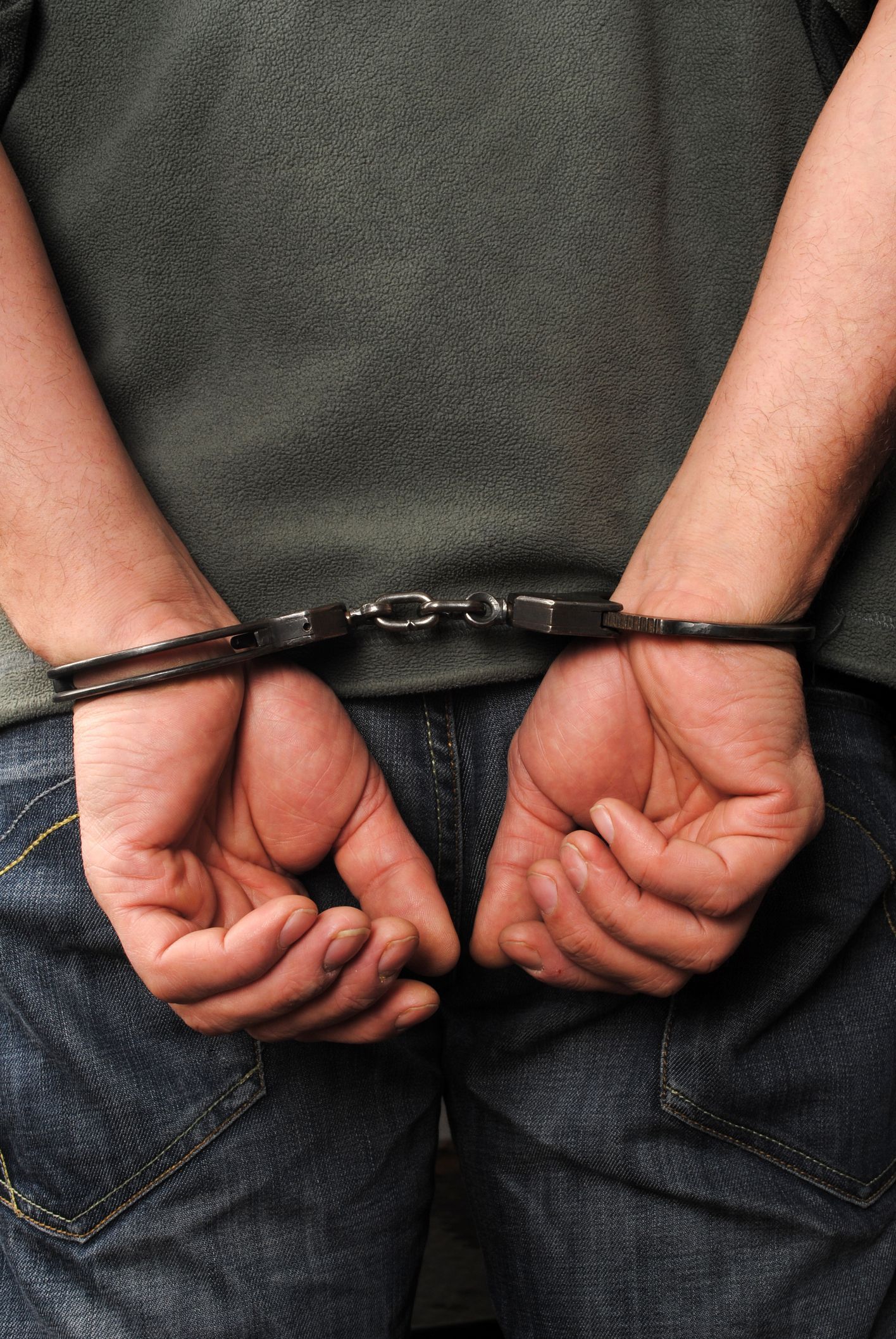 cuffed hands behind back