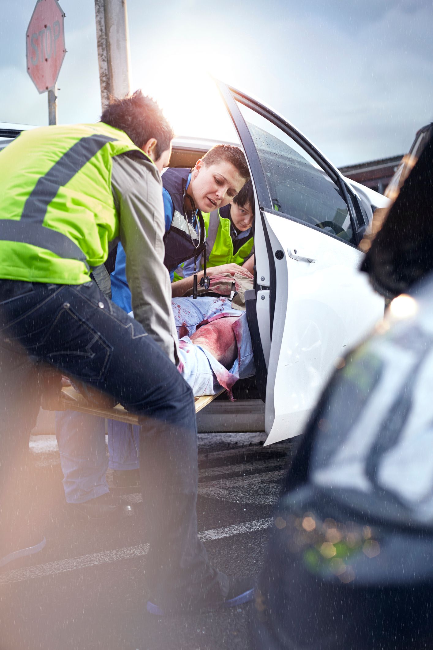 A man is laying on a stretcher in the back of a car.
