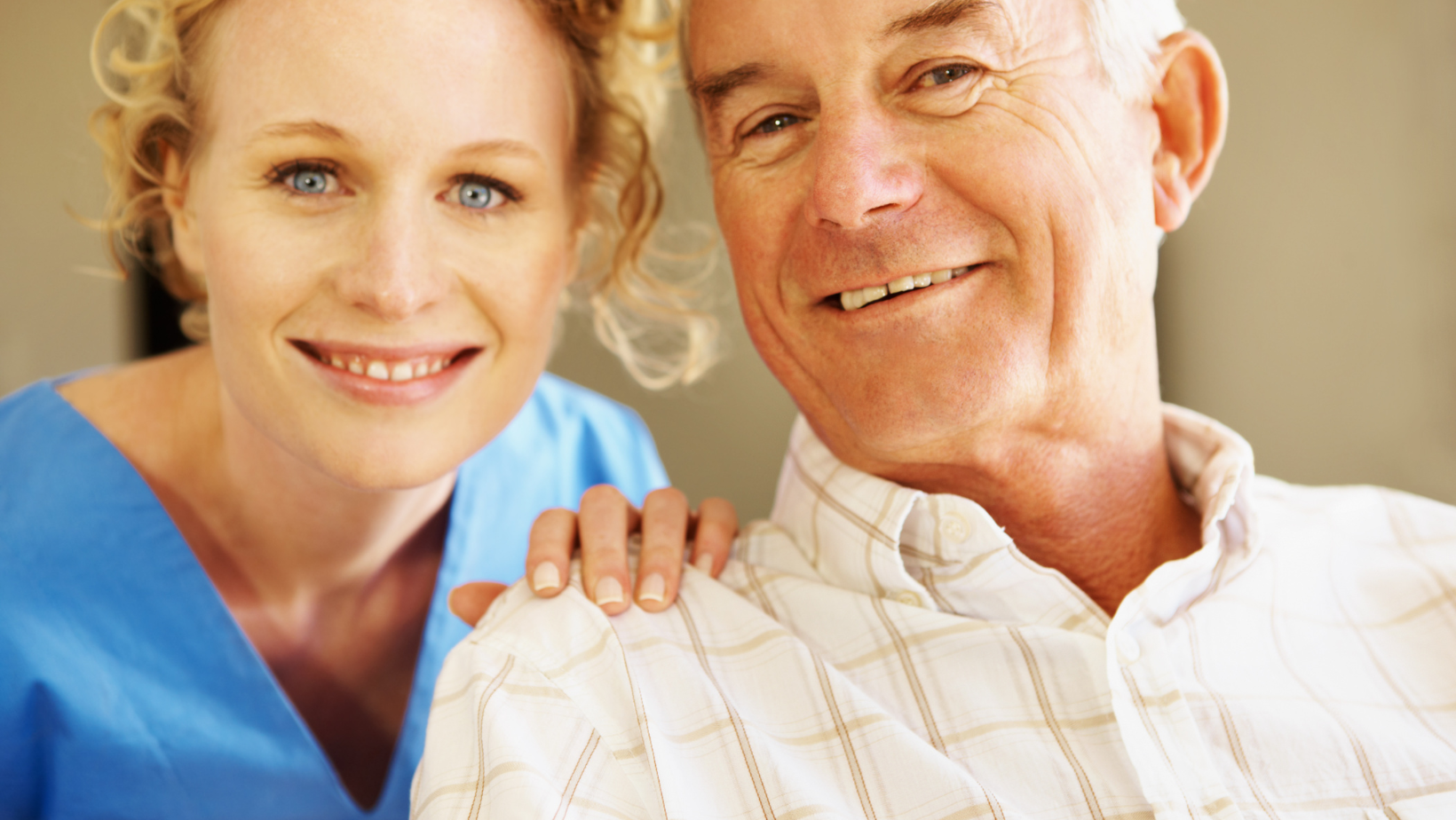 A nurse is putting her arm around an older man 's shoulder.