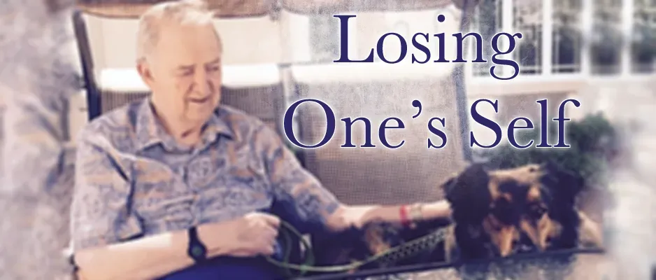 An elderly man is sitting in a chair with a dog.