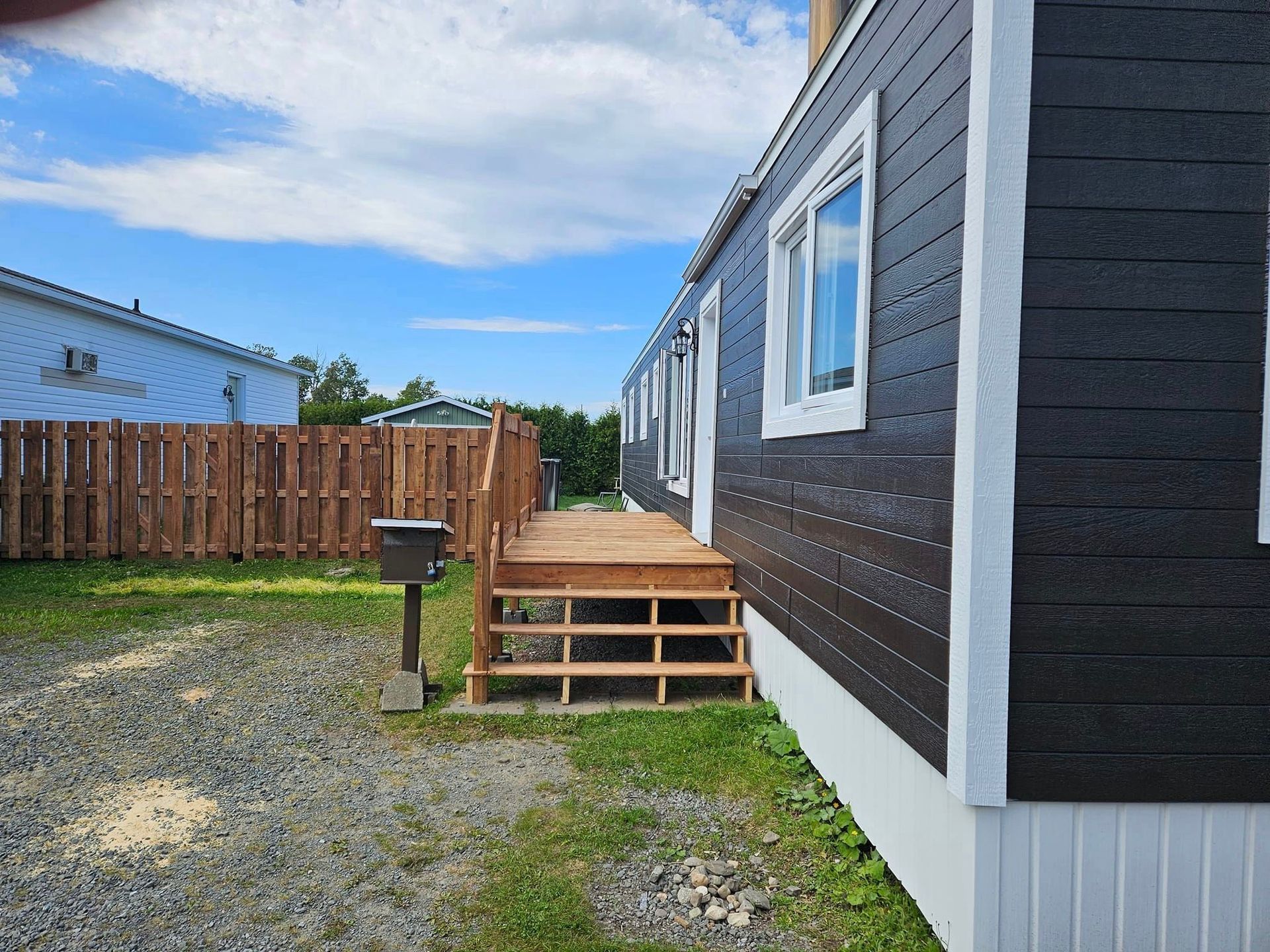 Un mobil-home avec une terrasse en bois et des escaliers
