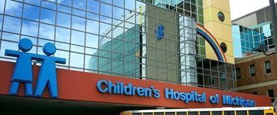 The Children’s Hospital of Michigan building, featuring a blue stylized children logo above the exterior entrance sign.