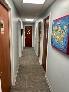 A brightly lit hallway features doors labeled 1, 2, and 3, with a colorful United States map hanging on the right wall.