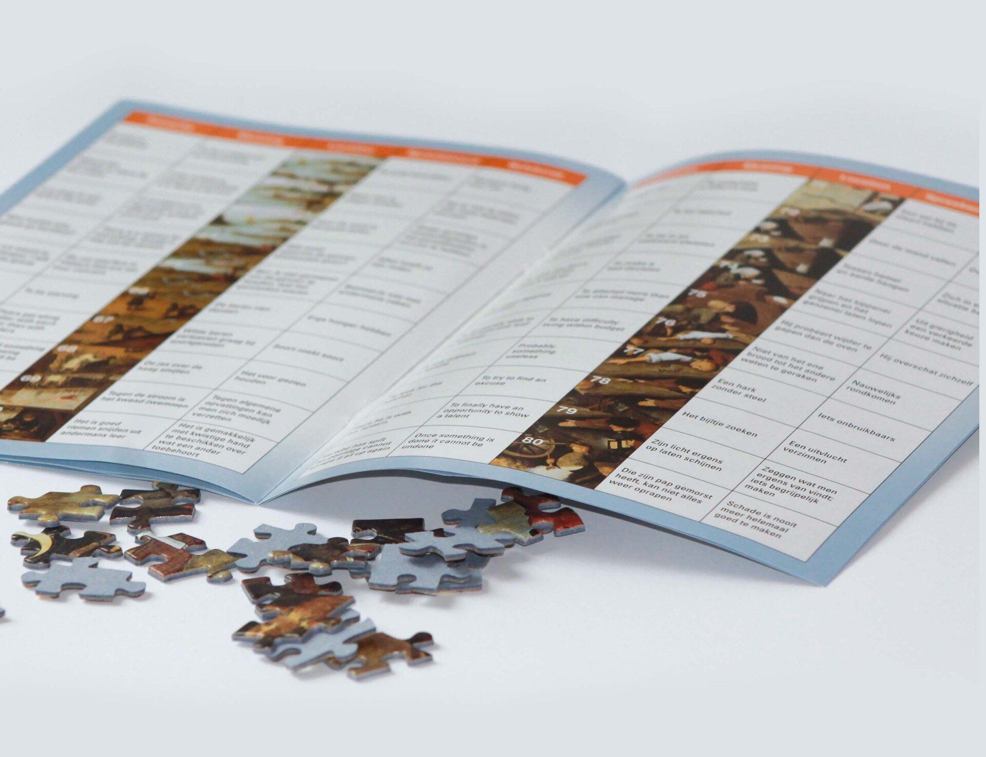Een opengelegd instructieboekje voor een legpuzzel ligt op een oppervlak naast een stapel losse puzzelstukjes.