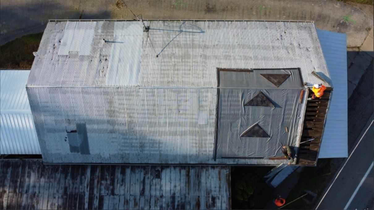 An aerial view of a building with a roof that is being repaired.