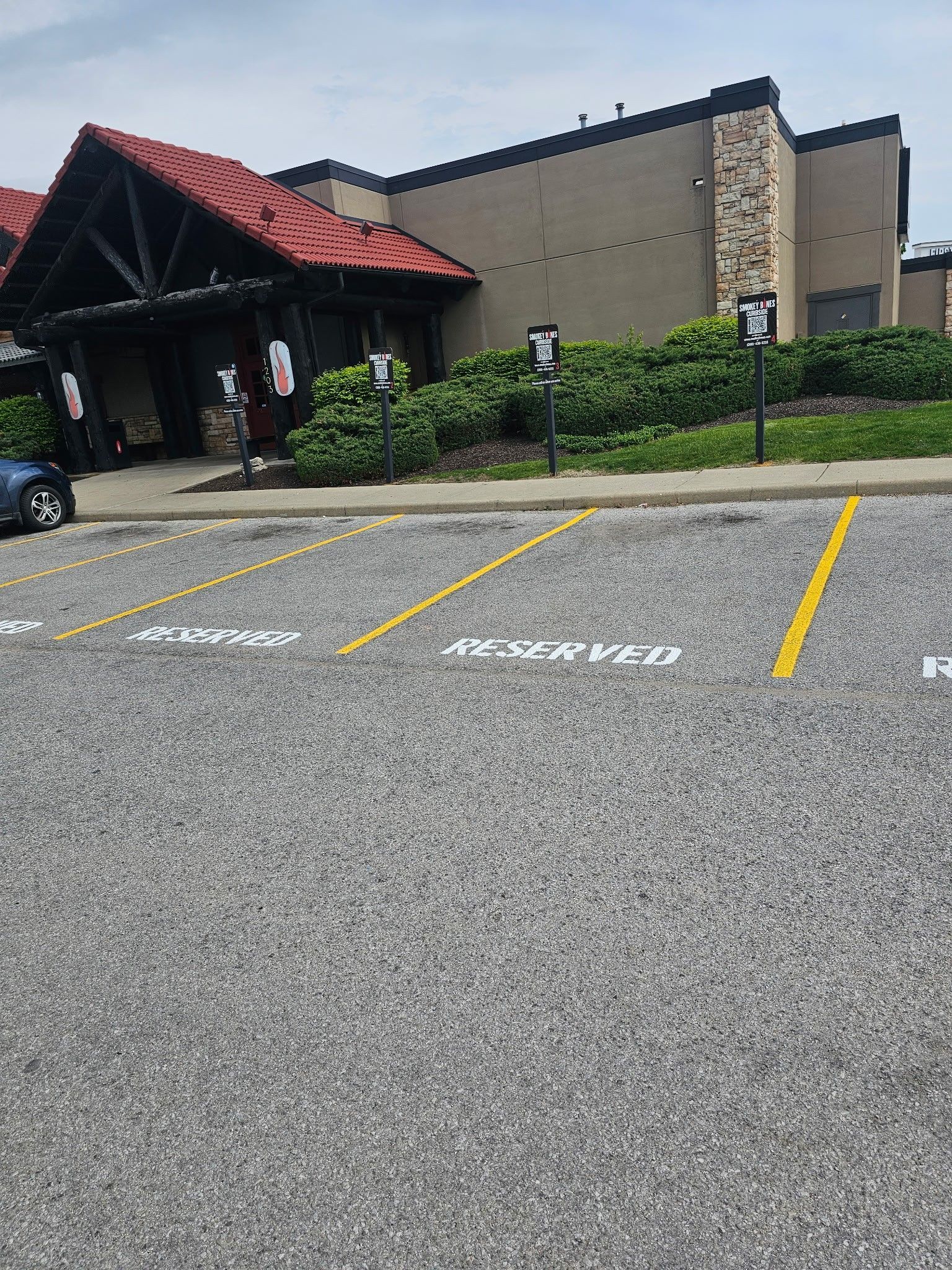 Parking lot spaces marked “No Parking” beside a building entrance with a red awning