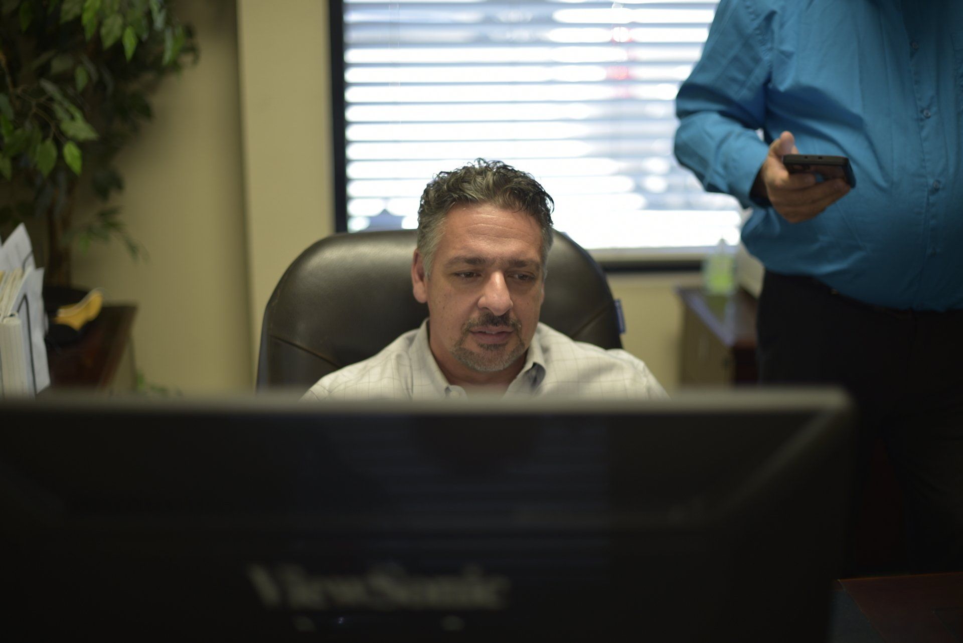 Chris Wolf sitting in front of a computer in an office.