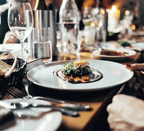 A person is taking a plate of food from a table.